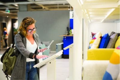 Woman standing in front of a tablet- representing product configuration for ERP for Manufacturing