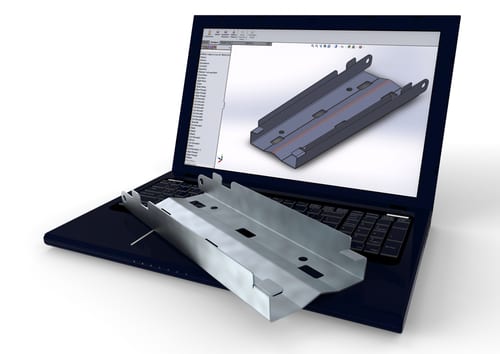 Laptop computer with a metal part CAD file on the screen and metal part on the keyboard. Our metal fabrication software links with CAD systems