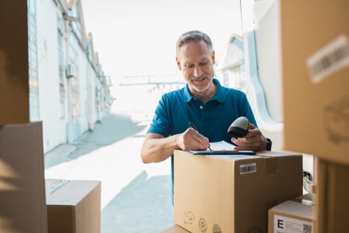 Man with a clipboard and cardboard boxes